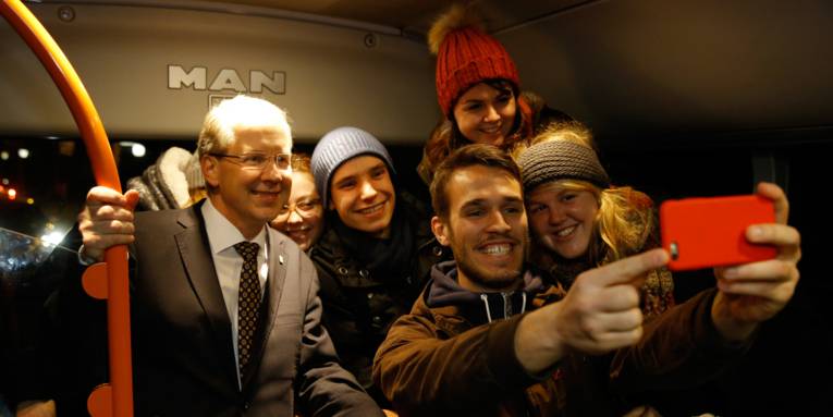 Der Oberbürgermeister macht mit Studenten im Linienbus ein Selfie
